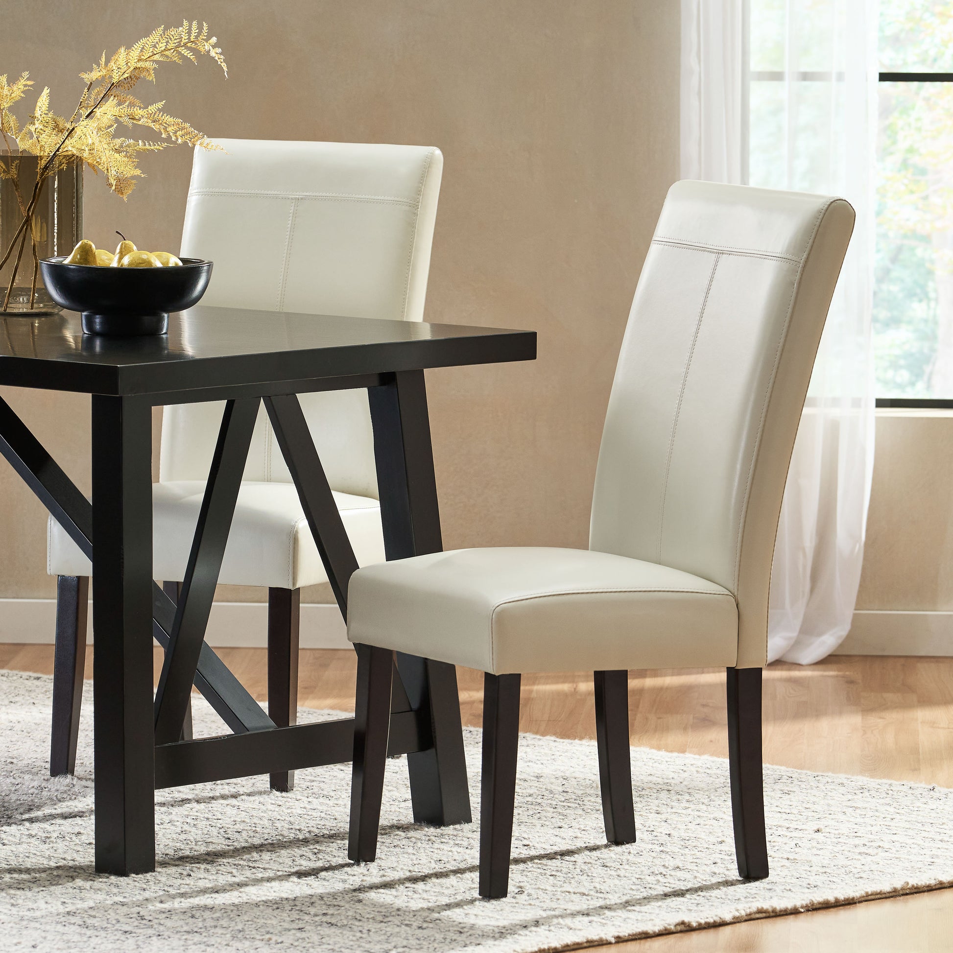 Cream leather dining chair with detailed stitching and dark wood legs