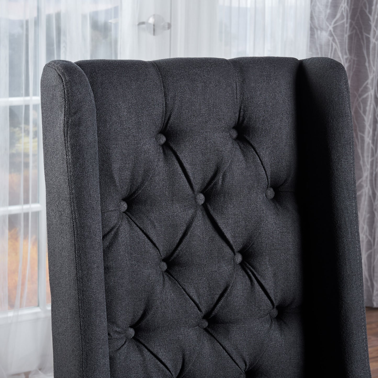Dark grey tufted fabric wingback chair back detail