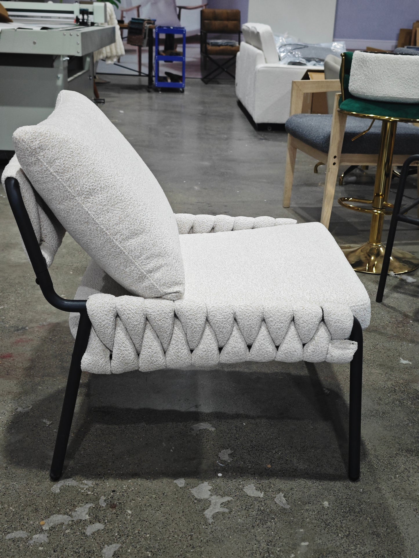Cream boucl armchair with black metal frame and textured woven seat detail