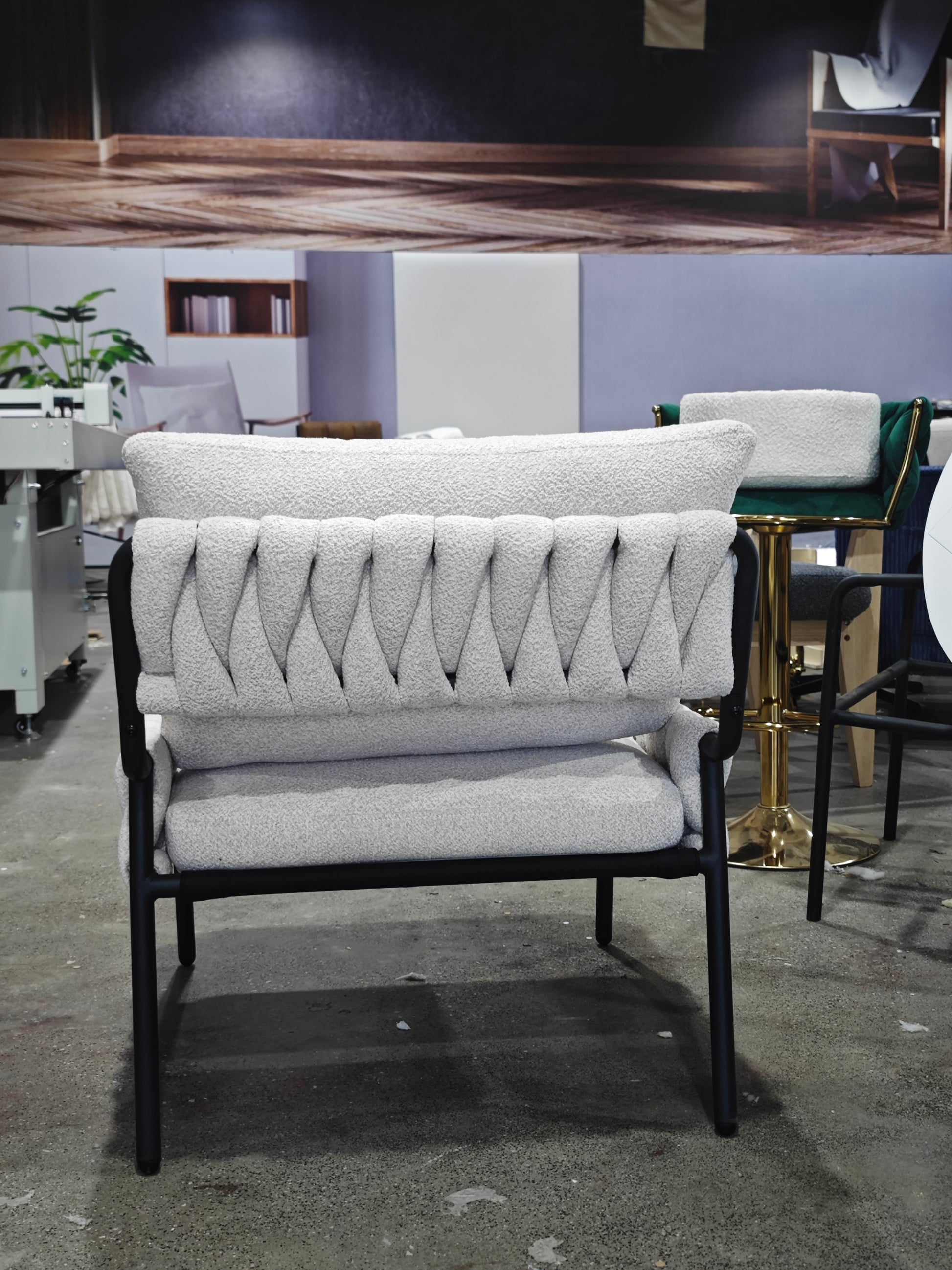 Light gray boucl armchair with black metal frame and textured backrest