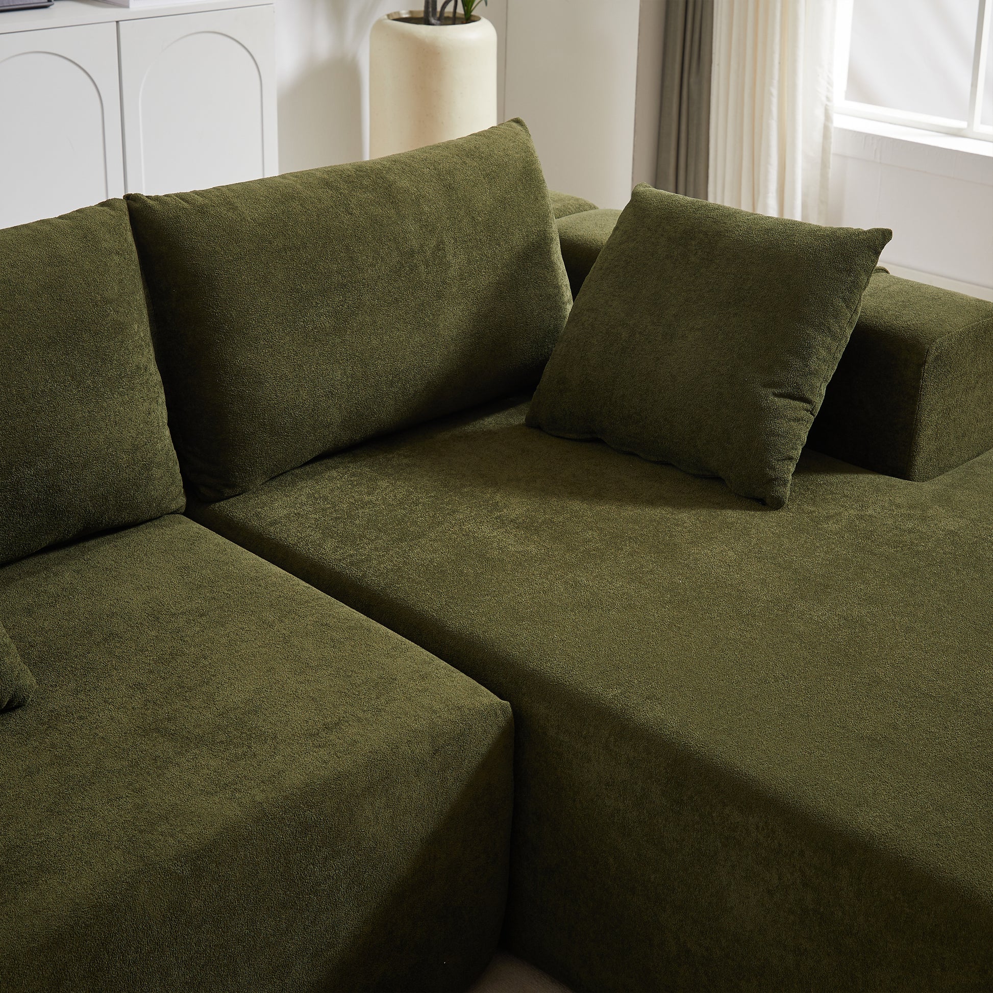 Olive green sectional sofa with textured fabric and plush cushions