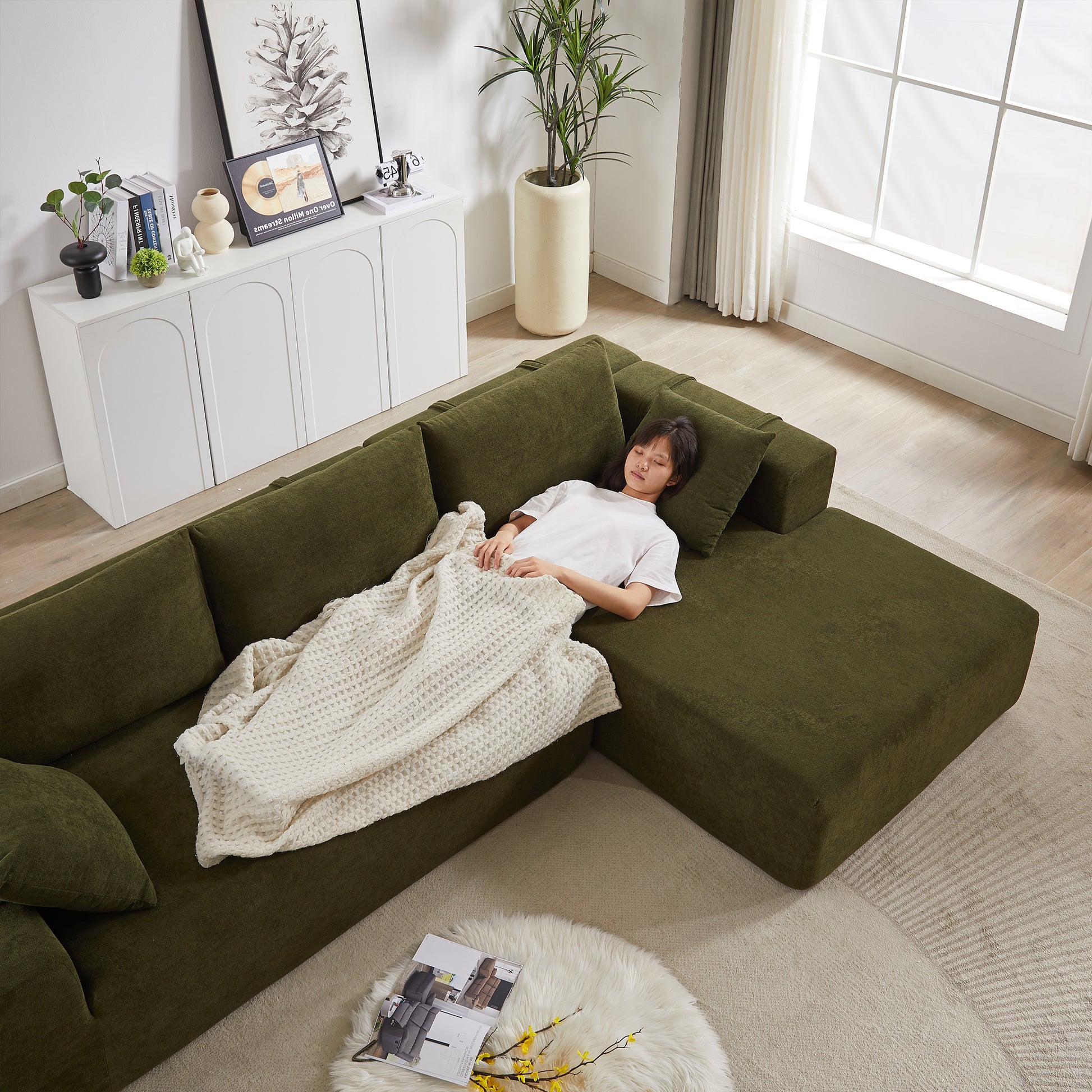Deep green sectional sofa with plush fabric and accent pillows