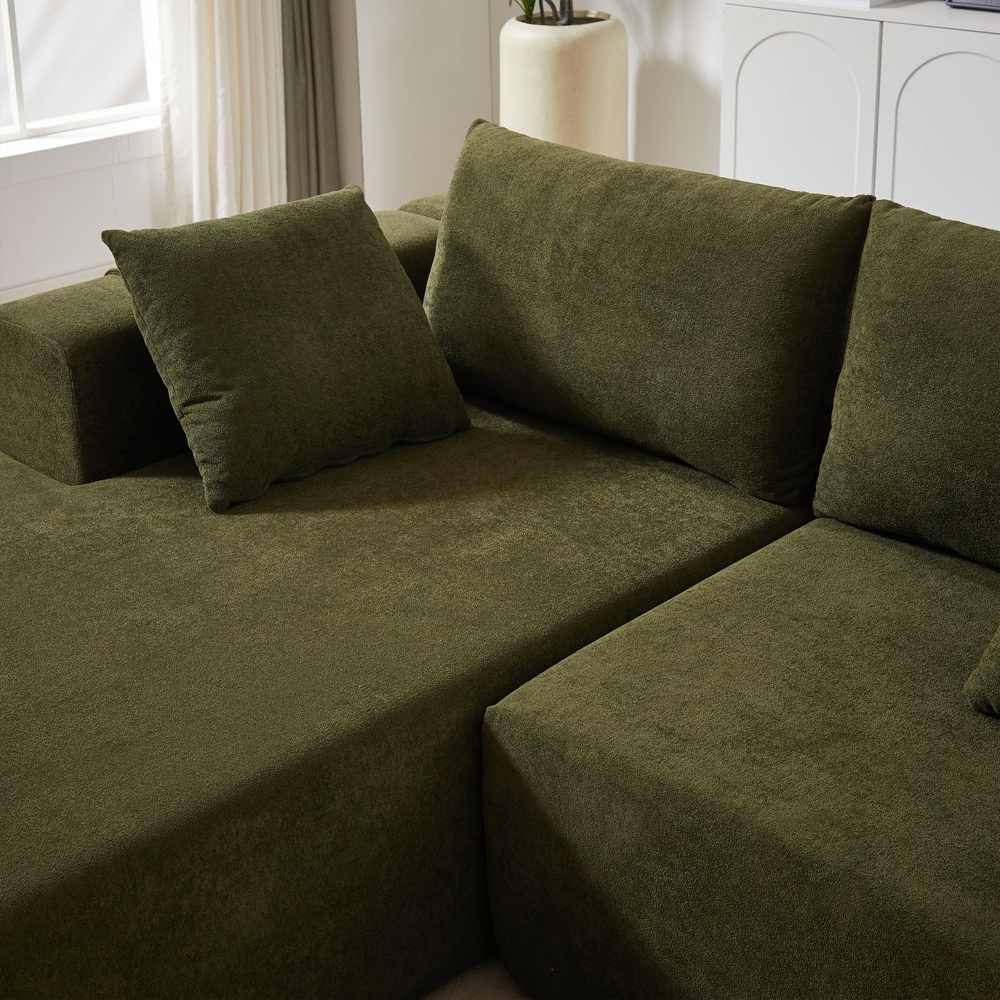 Deep green textured sectional sofa with plush throw pillows