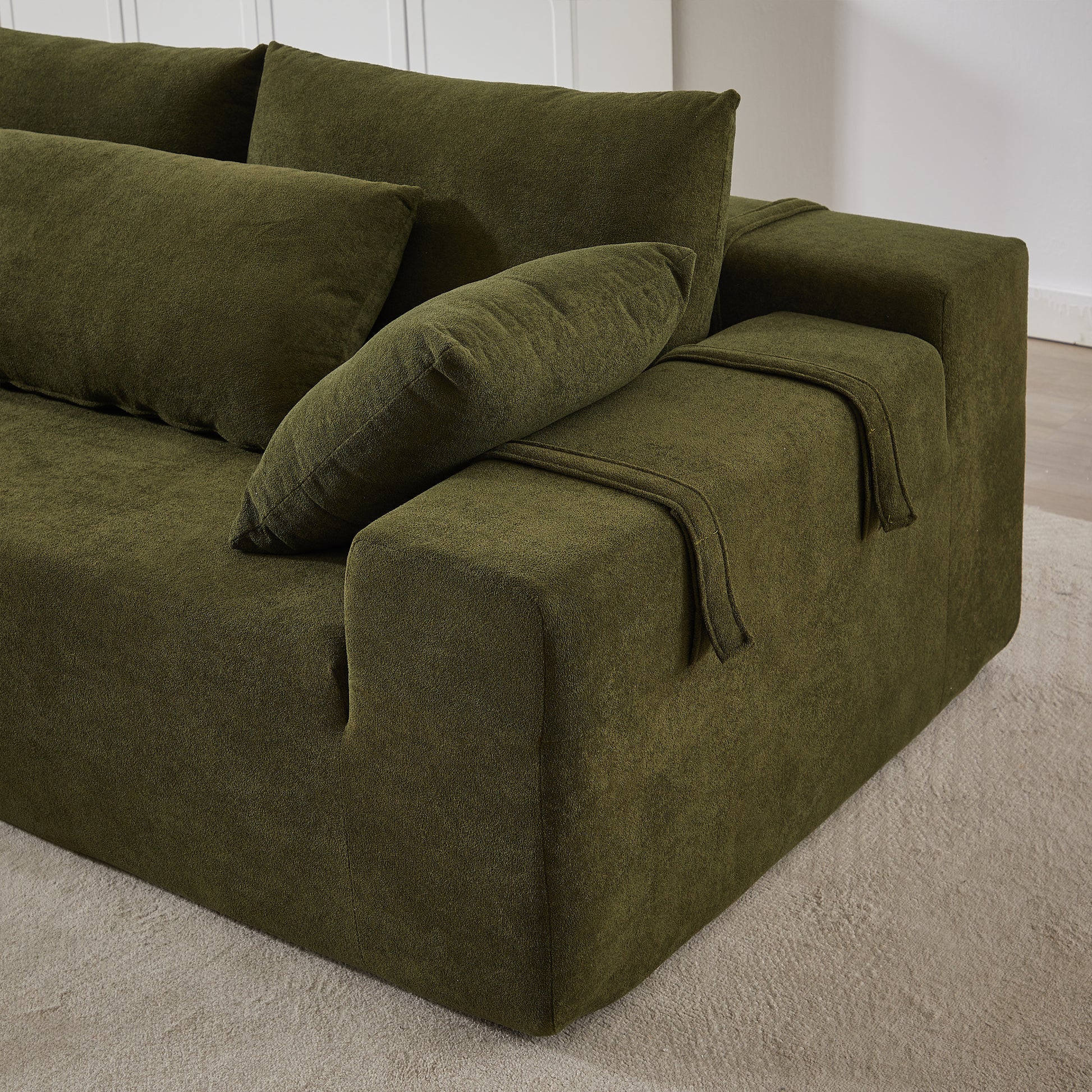 Deep green plush modular sofa with textured fabric and accent pillows perfect for modern living rooms