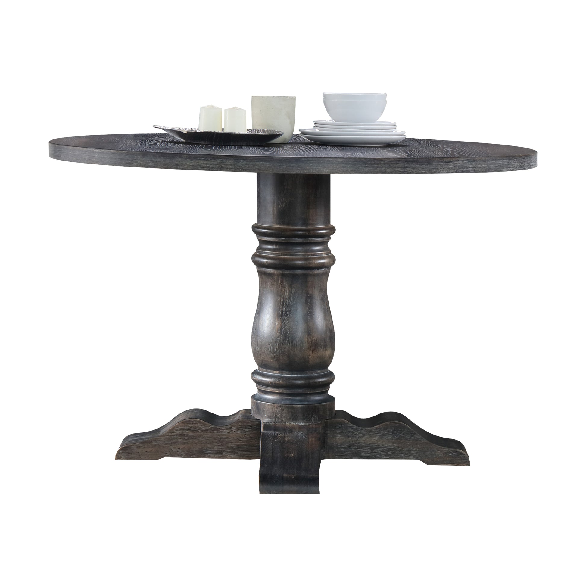 Dark wood pedestal dining table with stacked white plates and bowls