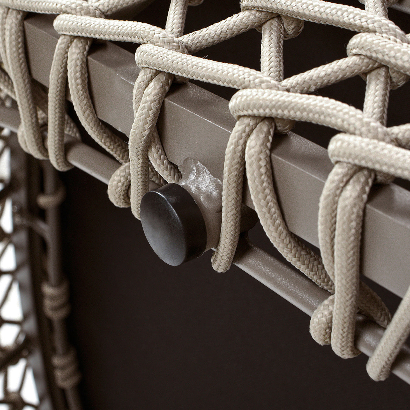 Closeup of beige rope detailing on a modern patio chair frame