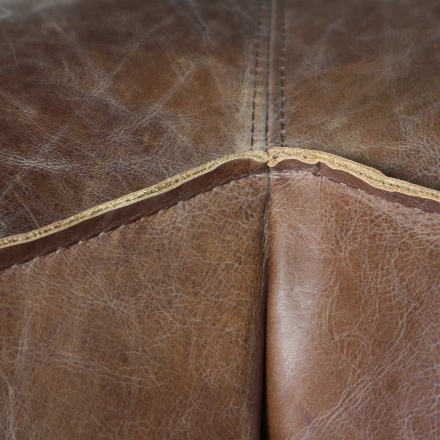Distressed brown leather texture with visible stitching perfect for a rustic sofa