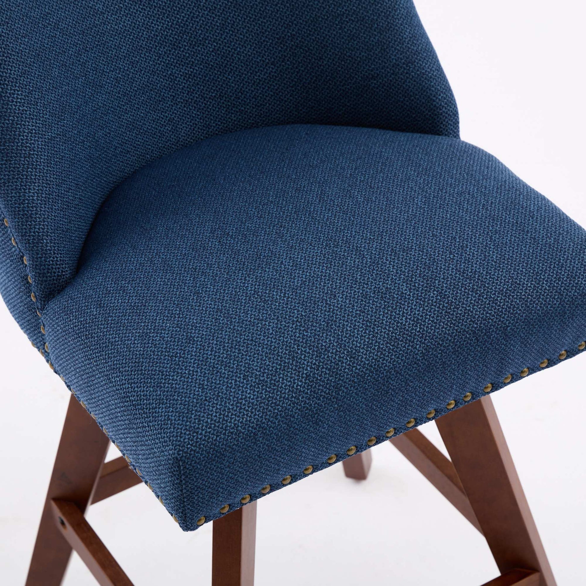 Closeup of navy blue fabric bar stool seat with brass nailhead trim