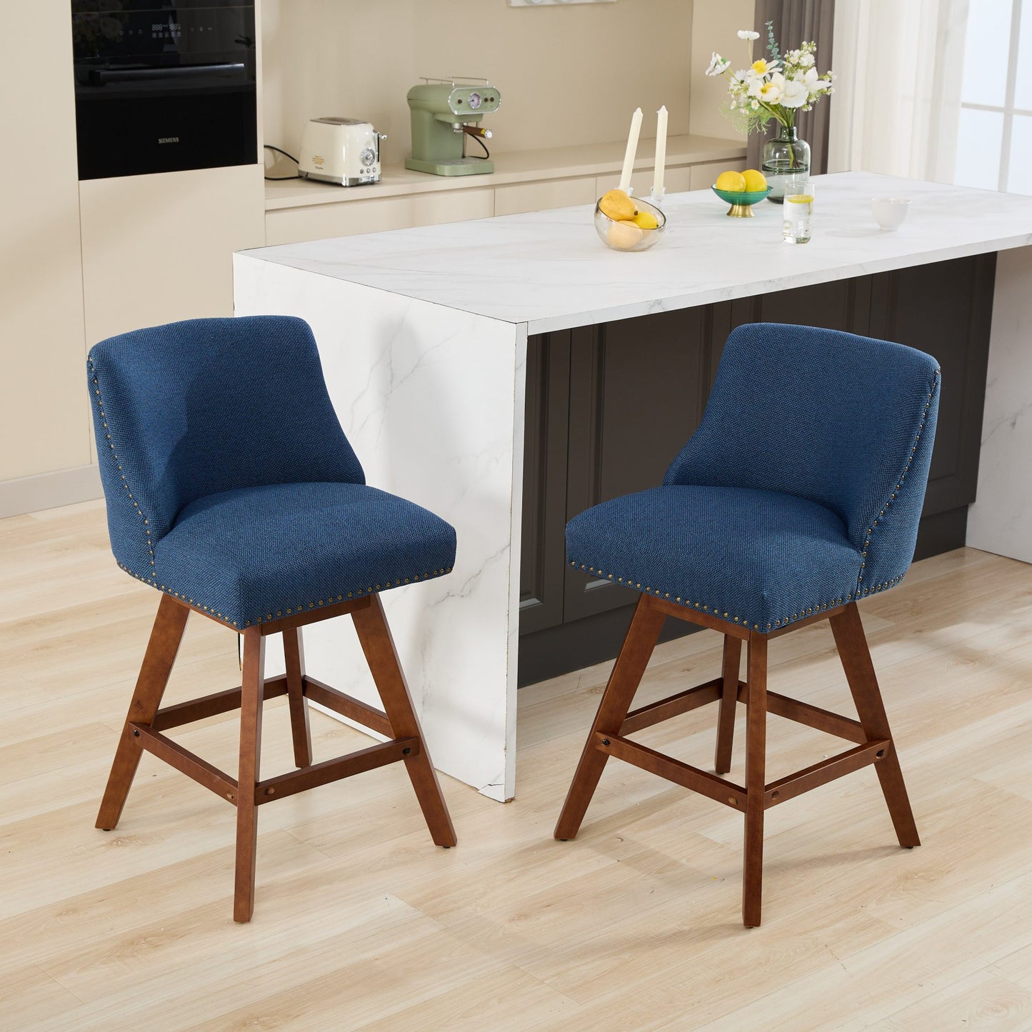 Two navy blue upholstered bar stools with wooden legs and brass nailhead trim