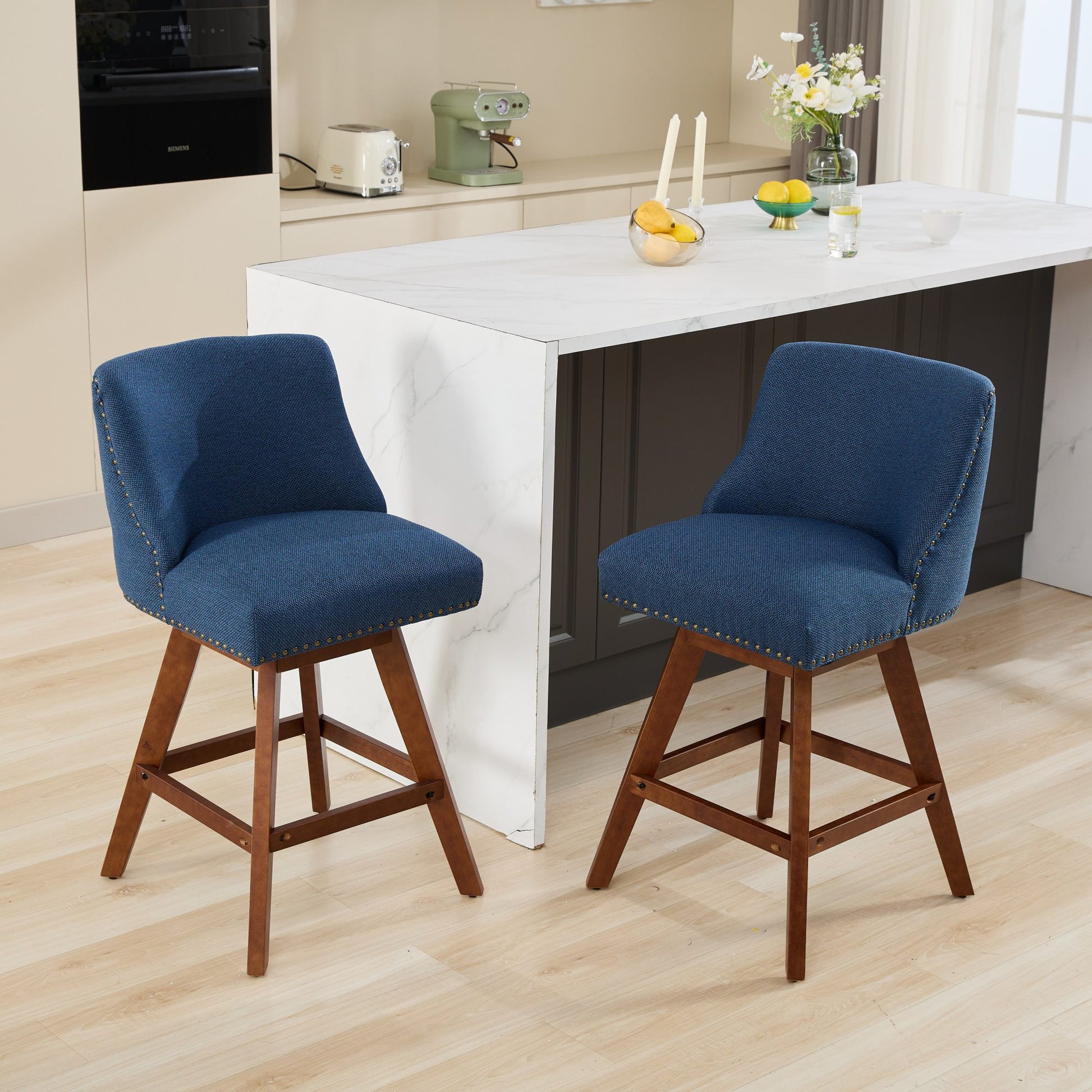 Two navy blue upholstered bar stools with wooden legs and brass nailhead trim