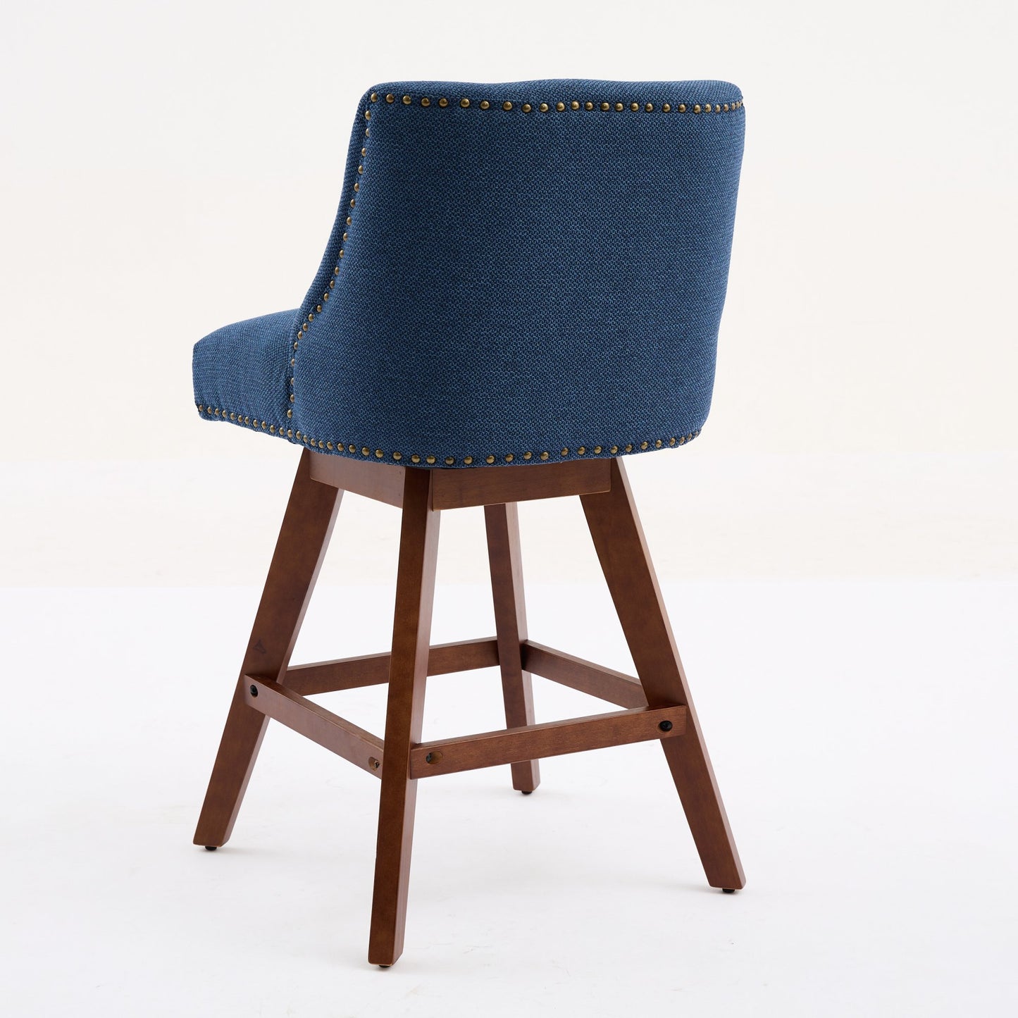 Blue upholstered bar stool with brass nailhead trim and dark wood legs
