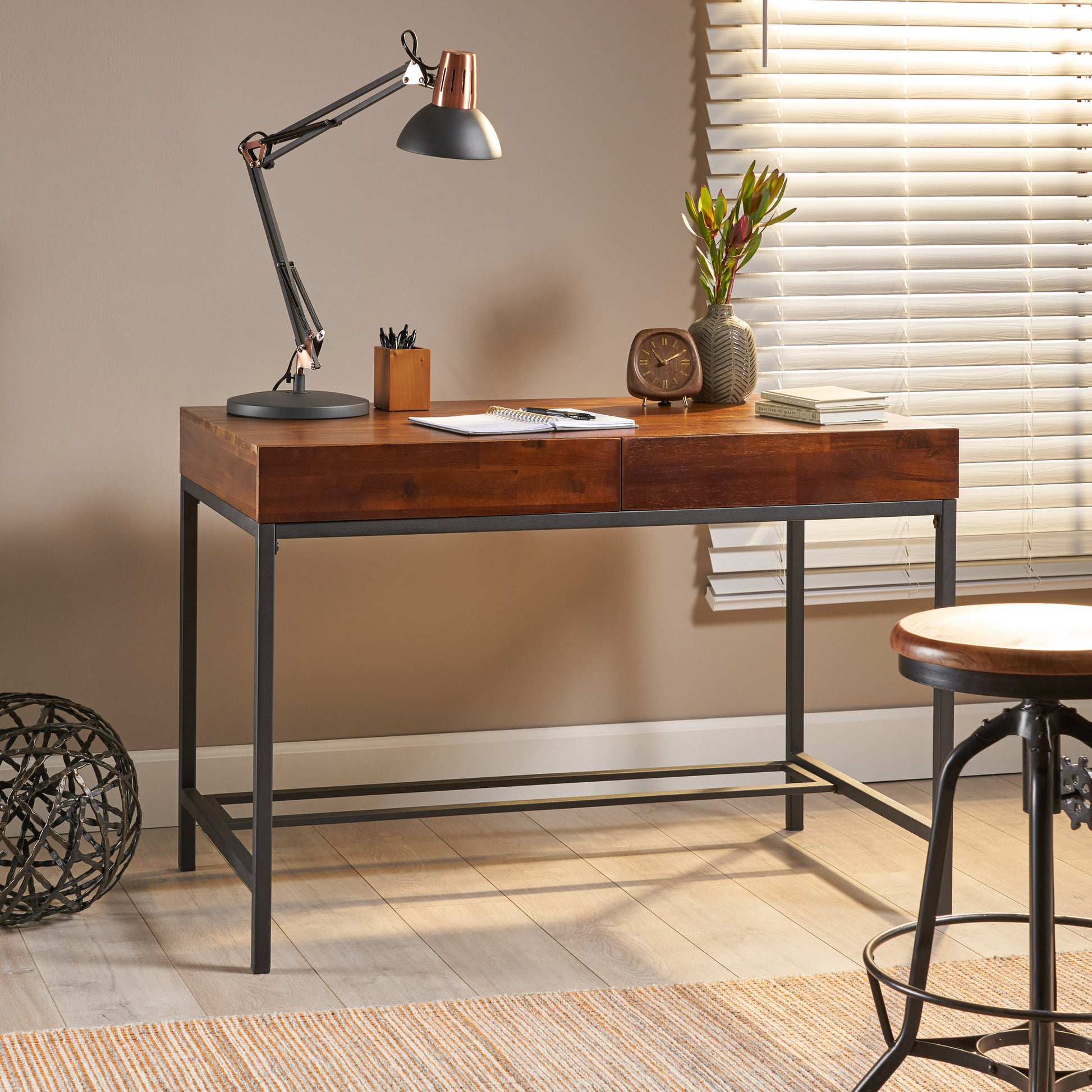Modern wooden desk with dark metal frame and adjustable task lamp ideal for home office setup