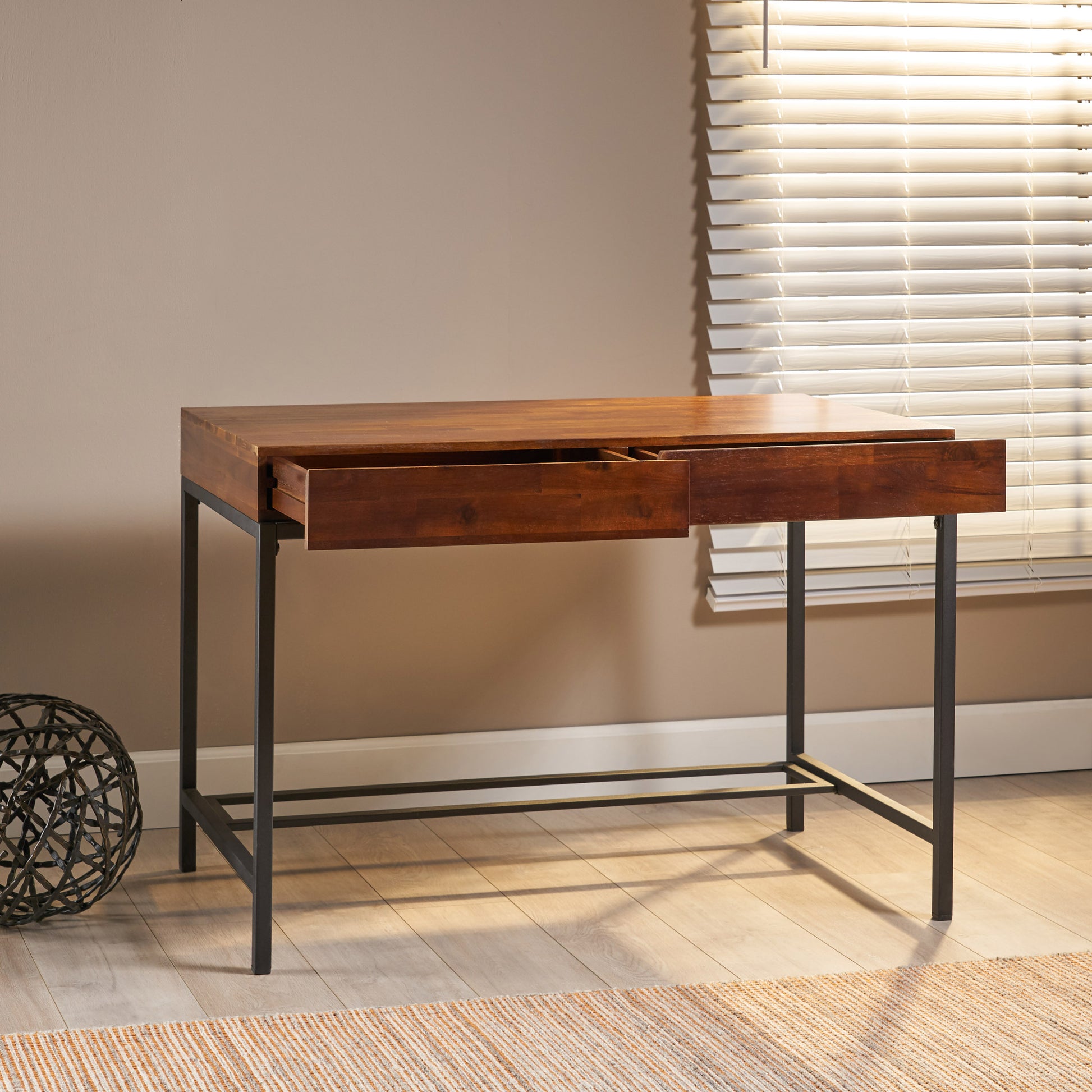 Dark wood writing desk with metal legs featuring two open drawers
