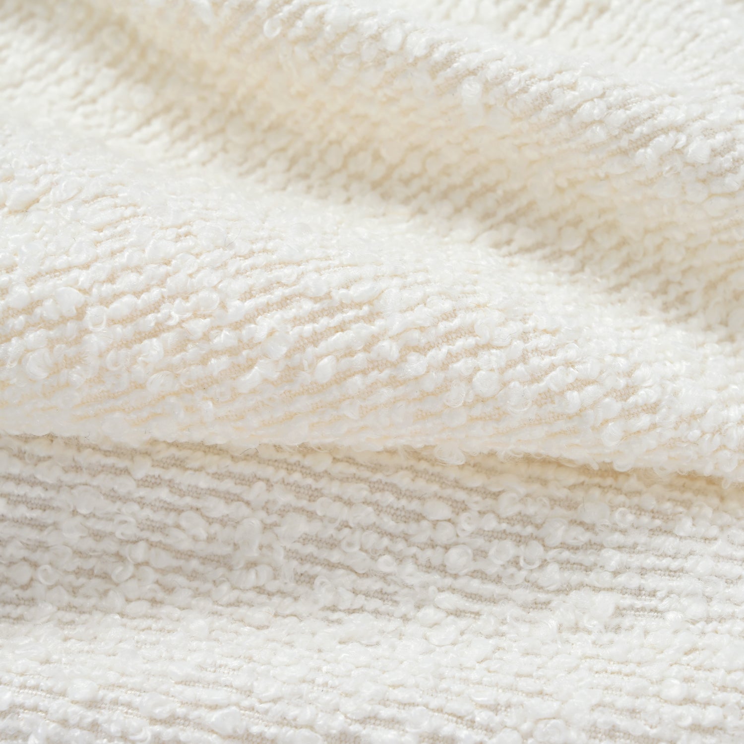 Cream boucle fabric with a textured loop pile perfect for upholstery and craft projects
