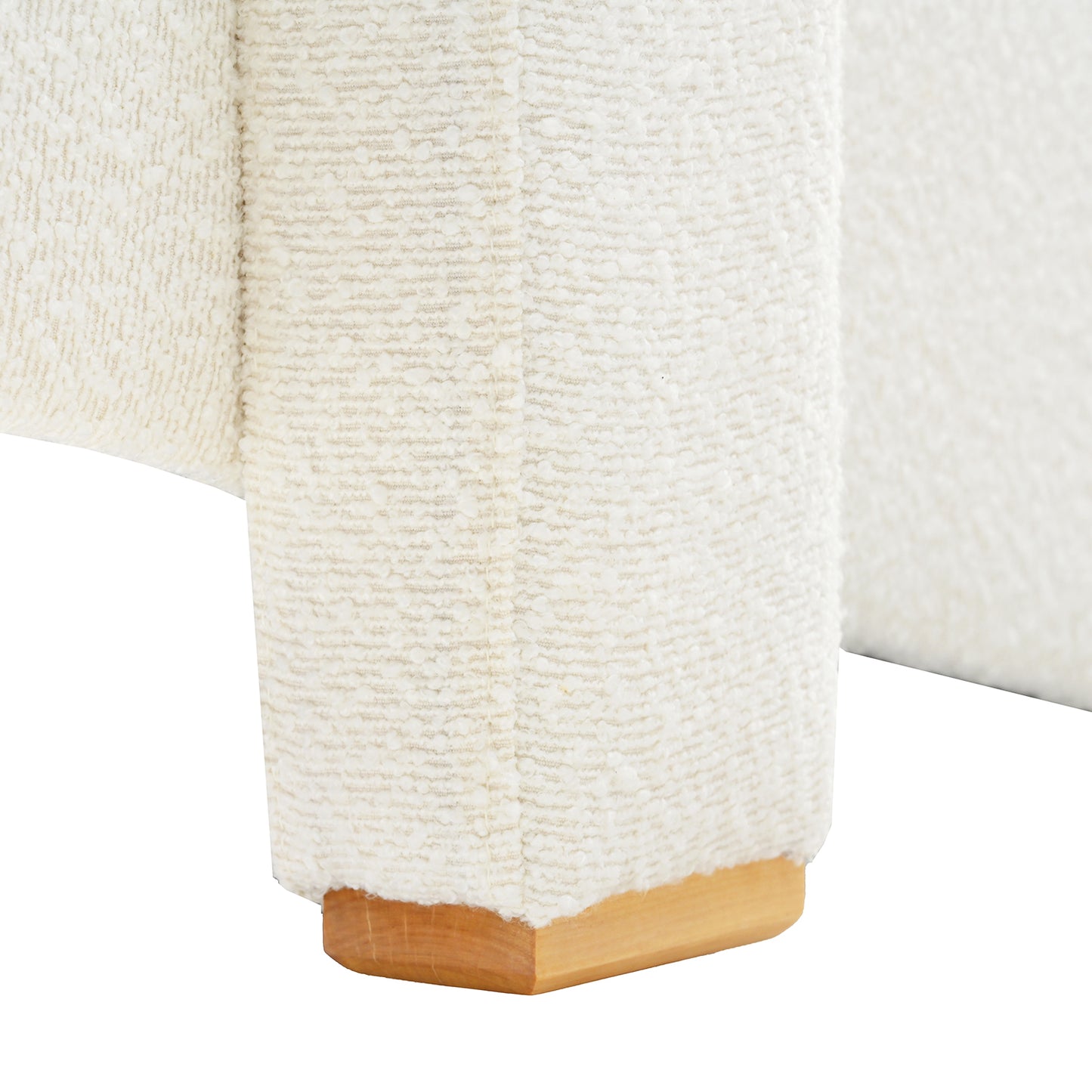 Closeup of a textured cream boucle fabric on a sofa leg with a natural wood base
