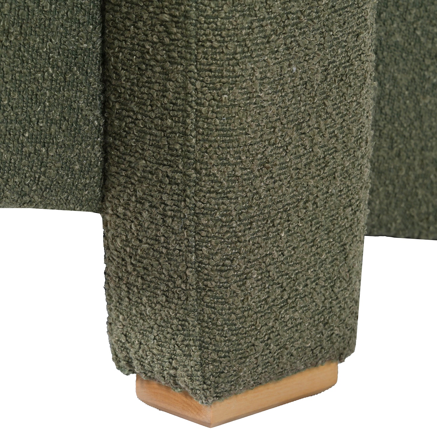 Closeup of green textured boucl fabric on a furniture leg with a wooden base