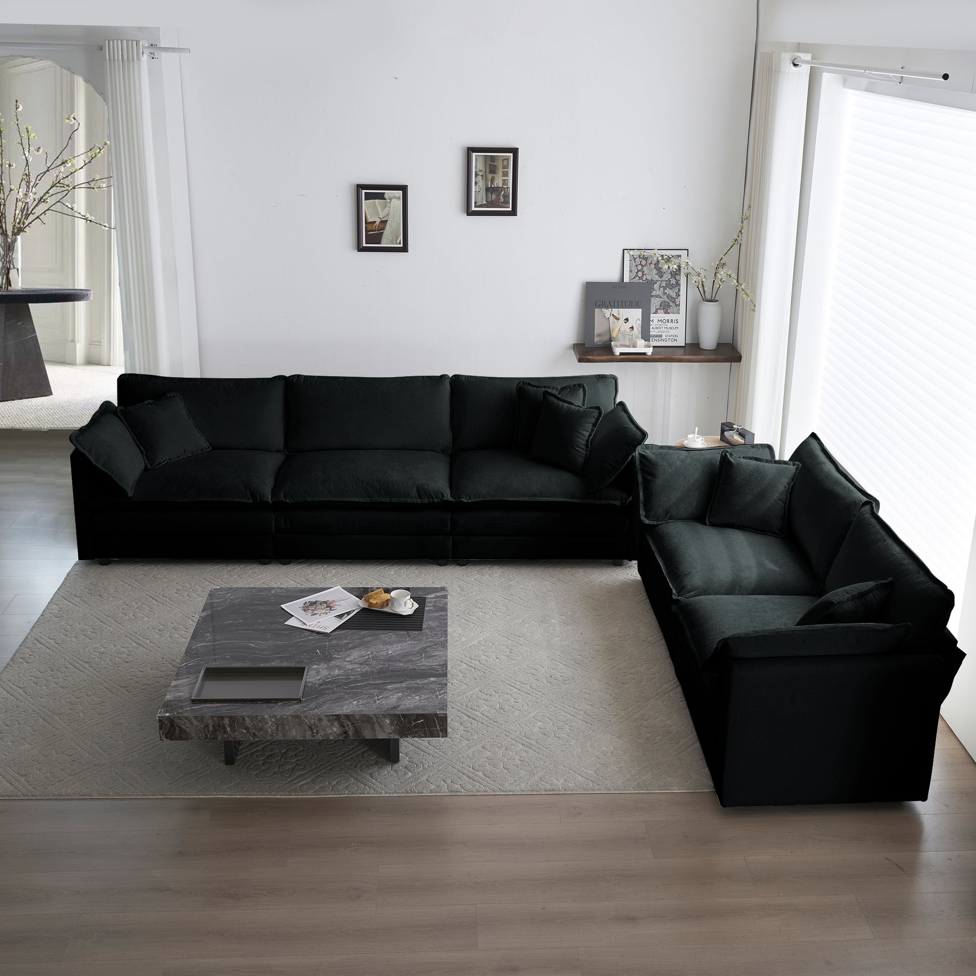 Spacious modular black velvet sofa with plush throw pillows perfect for a modern living room