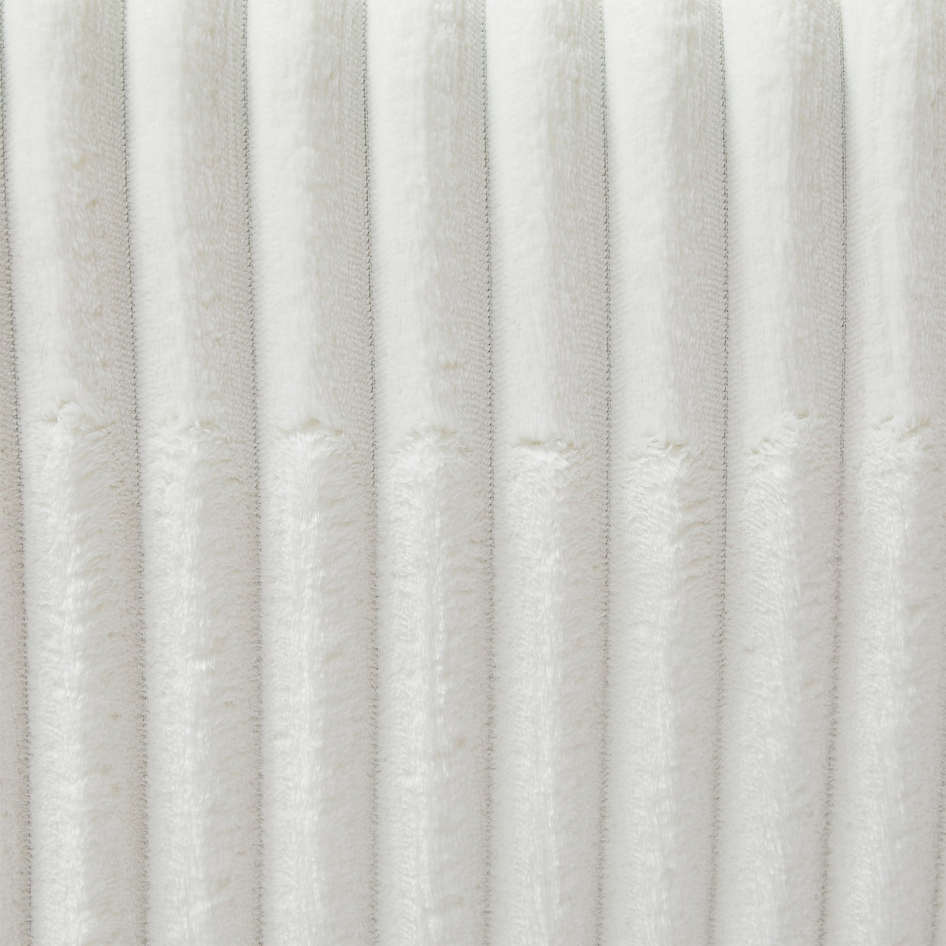 Closeup of textured white plush fabric with vertical ribbed detail perfect for cozy home decor