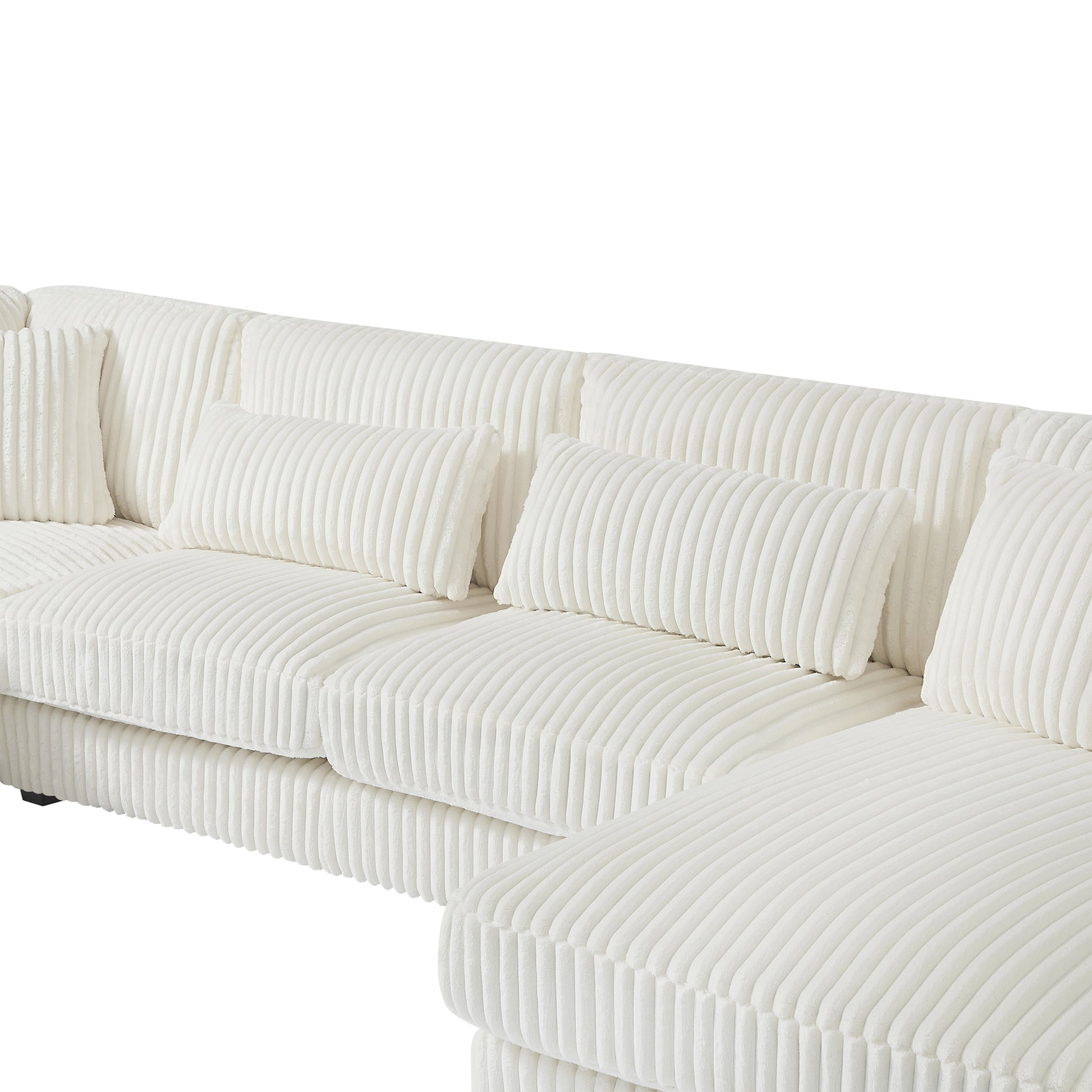 Closeup of a plush white corduroy sectional sofa with matching throw pillows