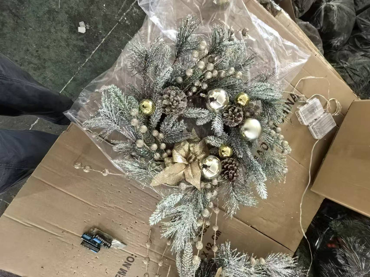Frosted pine artificial Christmas wreath with gold and silver ornaments and pinecones
