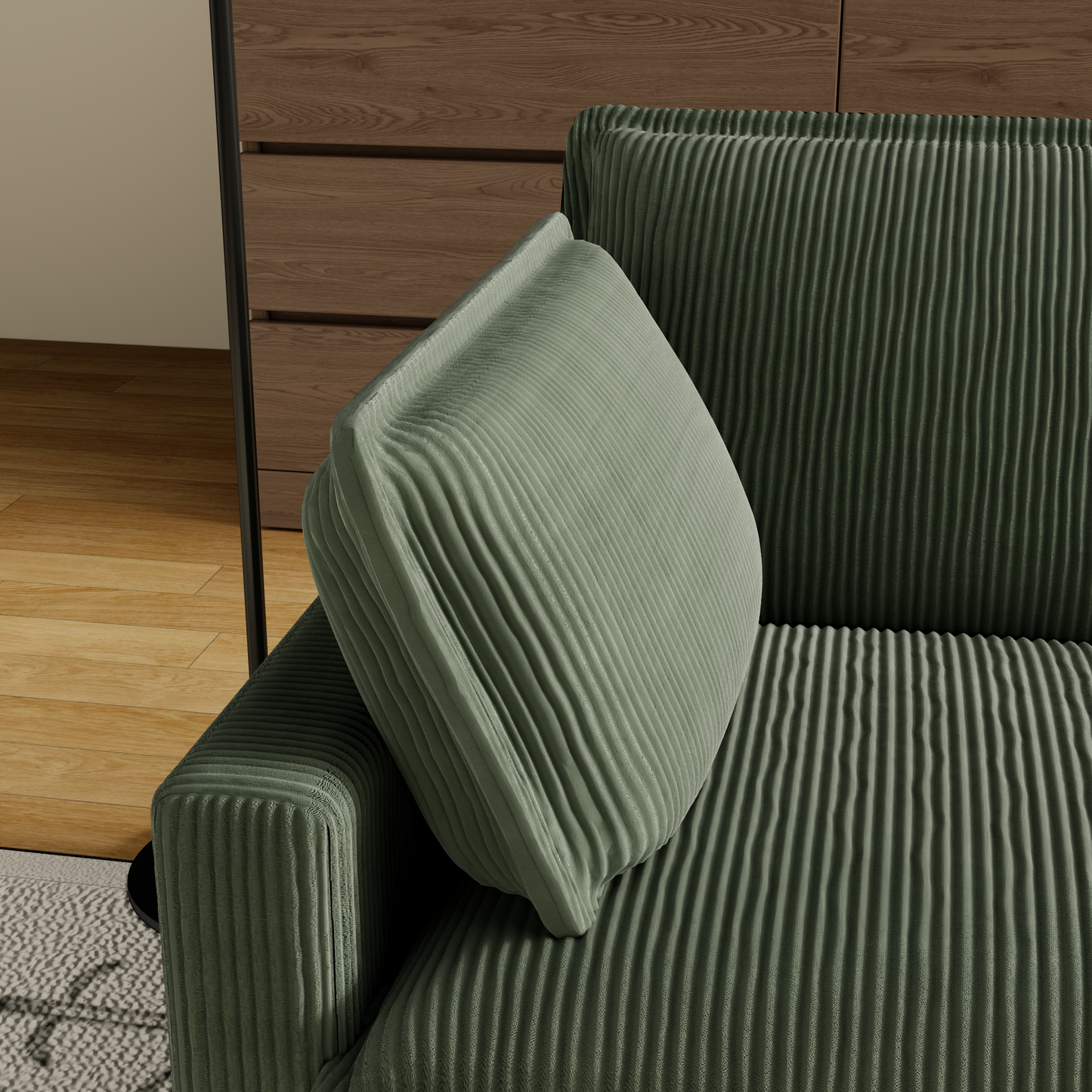 Closeup of plush sage green corduroy sofa armrest and cushion detail