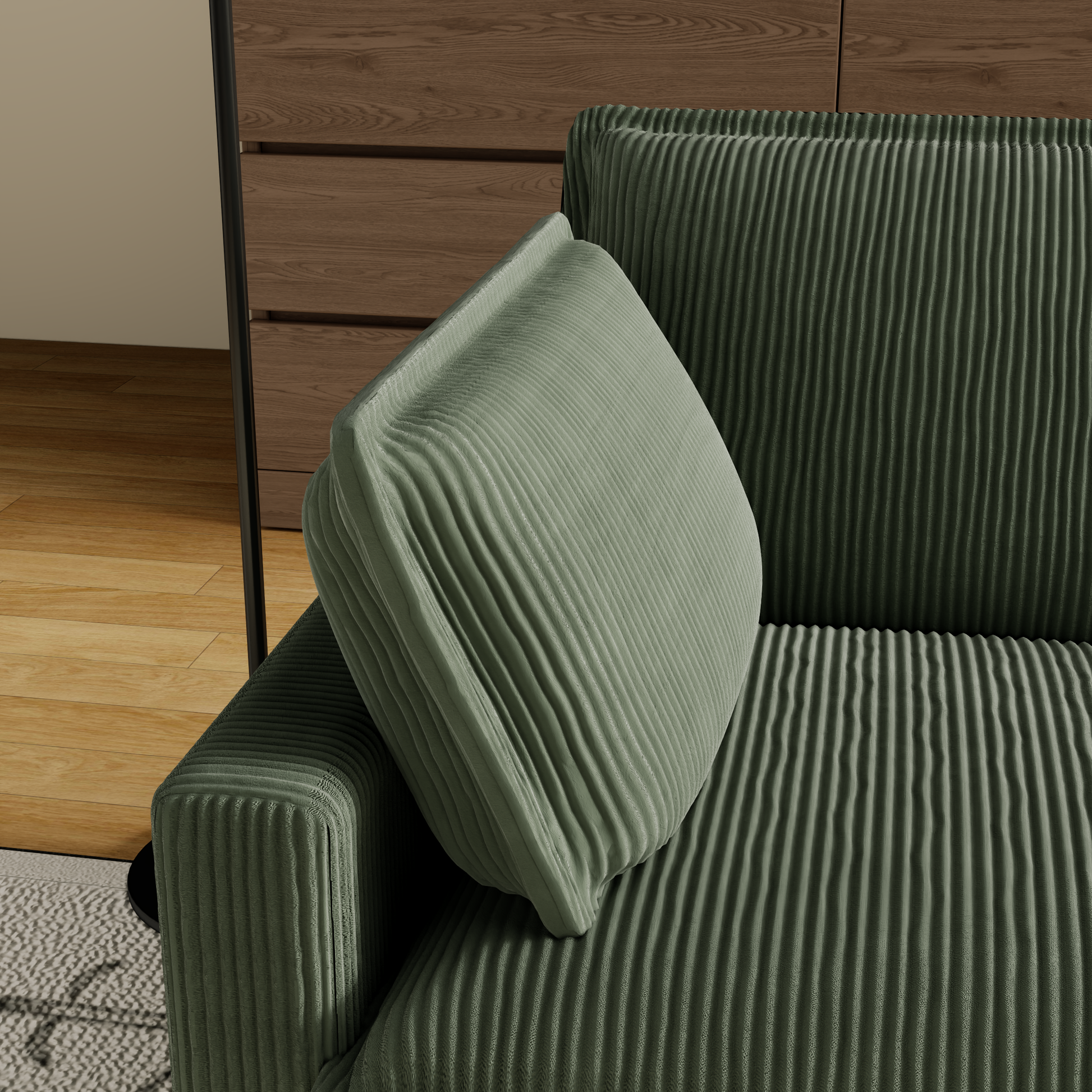 Closeup of plush sage green corduroy sofa armrest and cushion detail