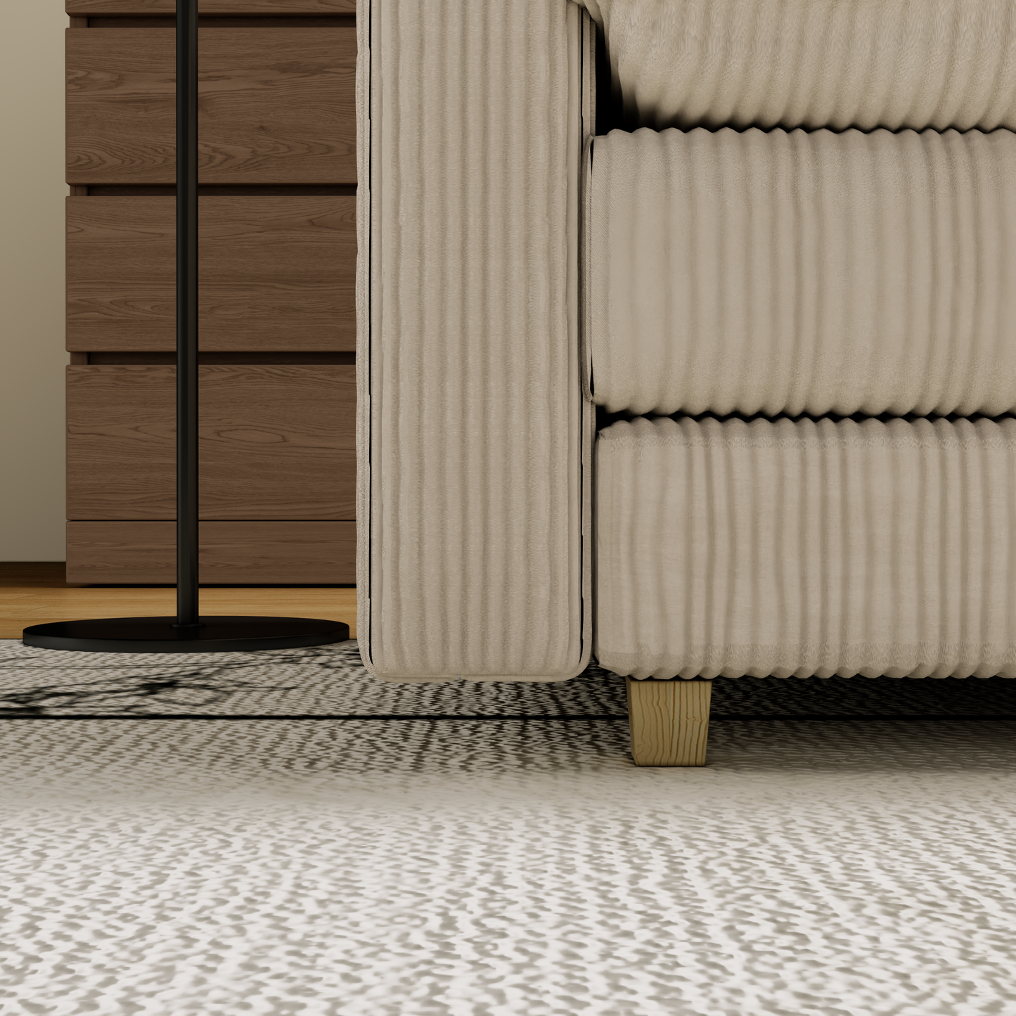 Beige corduroy sofa armrest with visible stitching detail and wooden feet