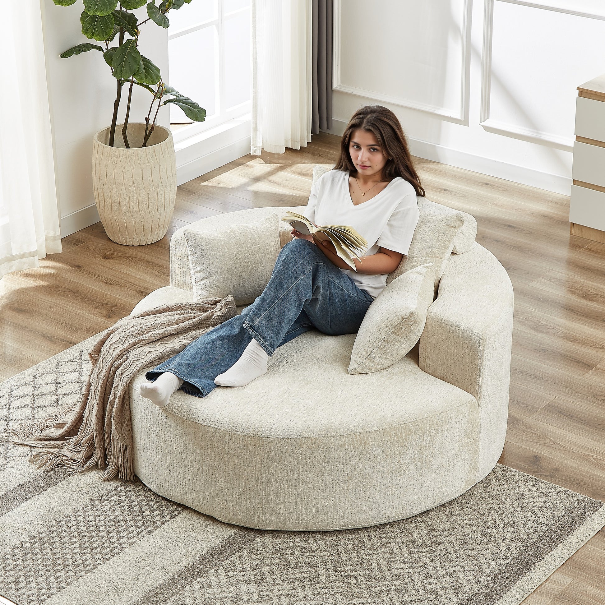 Cozy circular cream boucle fabric accent chair with a woman reading
