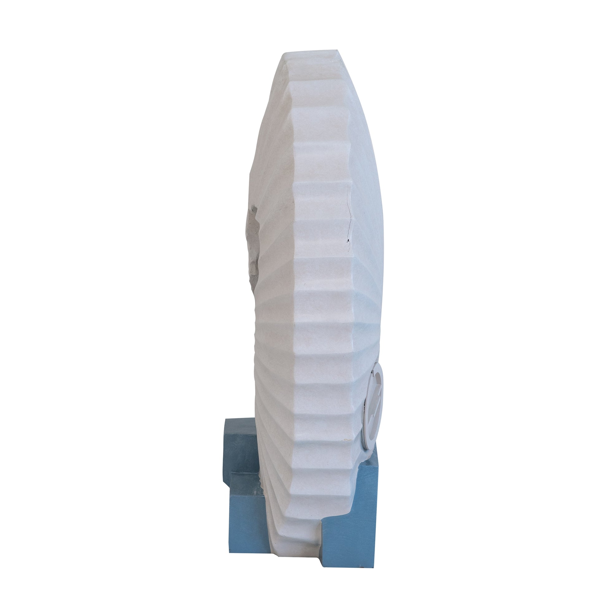 Abstract white stone sculpture with ribbed texture on blue pedestal base
