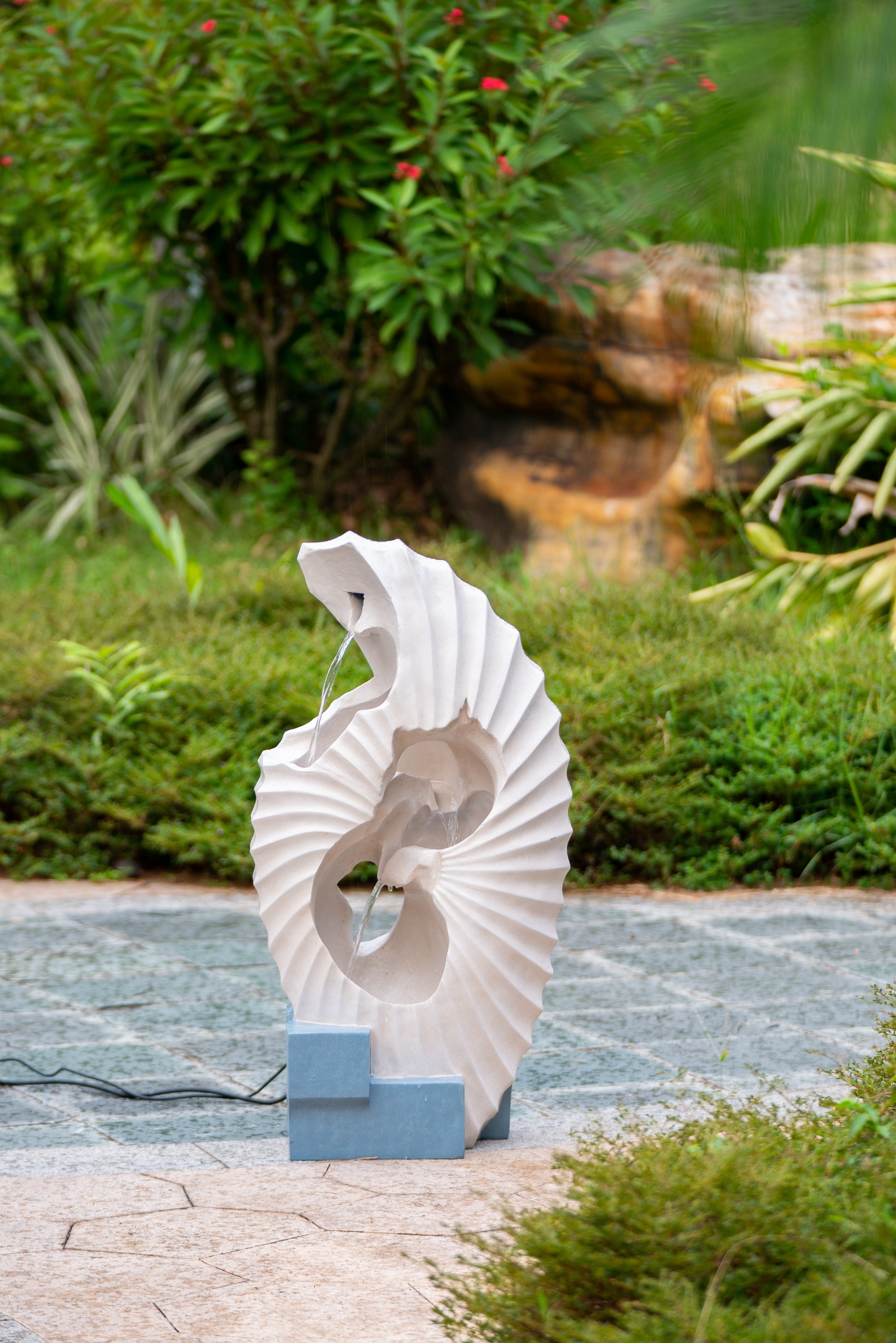 Modern white spiral garden fountain with cascading water detail