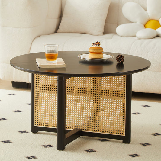 Round black coffee table with woven cane storage and minimalist design
