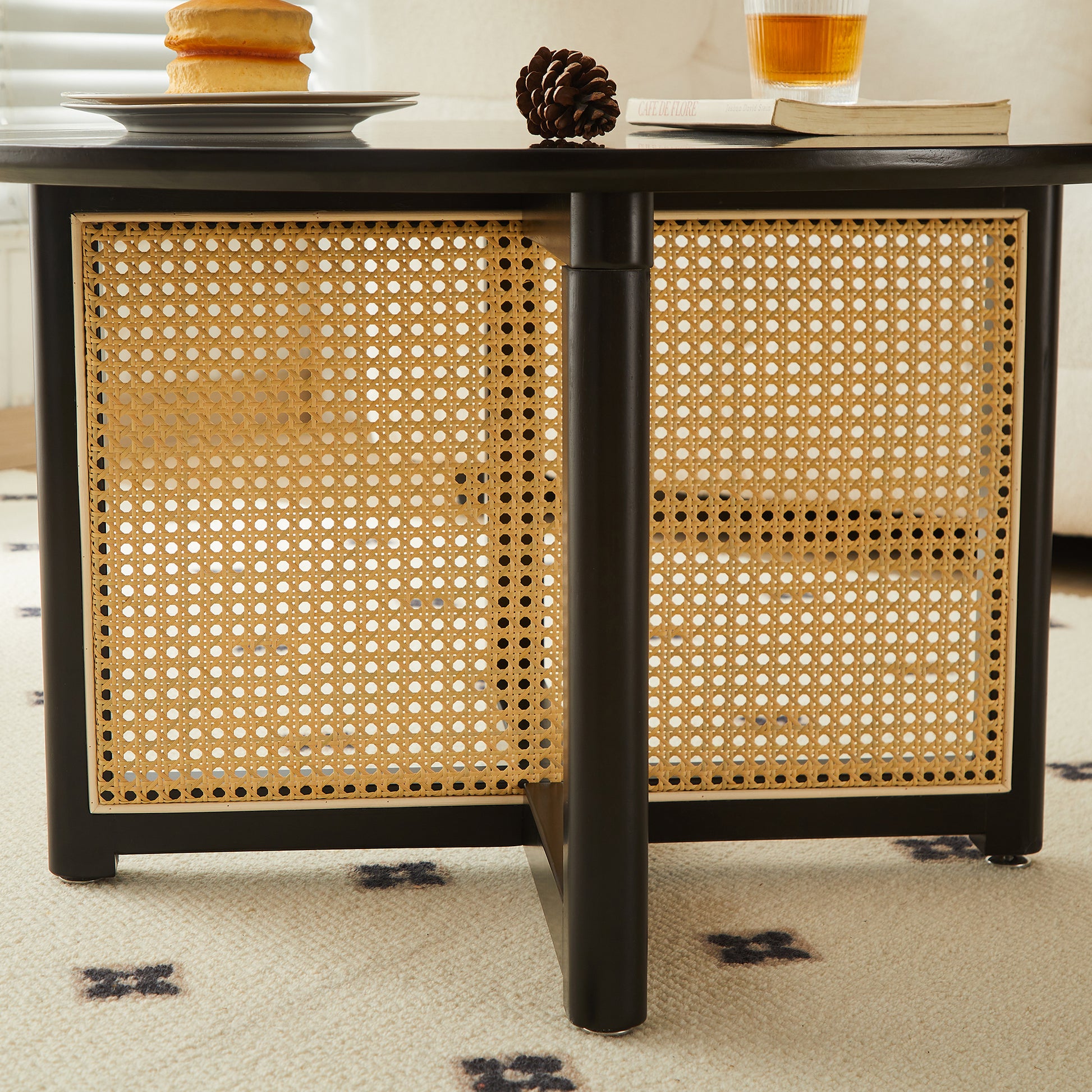 Black cane storage cabinet with a woven rattan front panel and metal legs