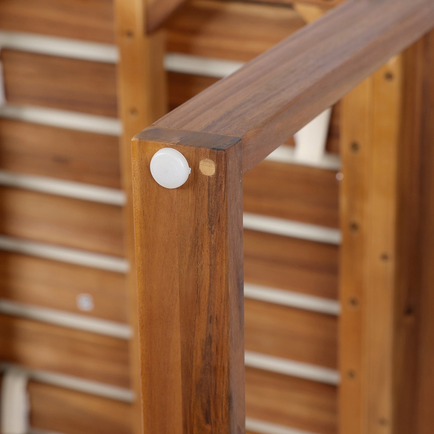 Close up of wooden chair leg with white protective cap and visible grain detail