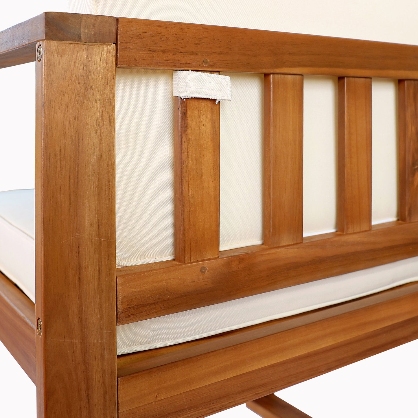 Closeup of a natural wood outdoor bench frame with cream cushions and visible grain