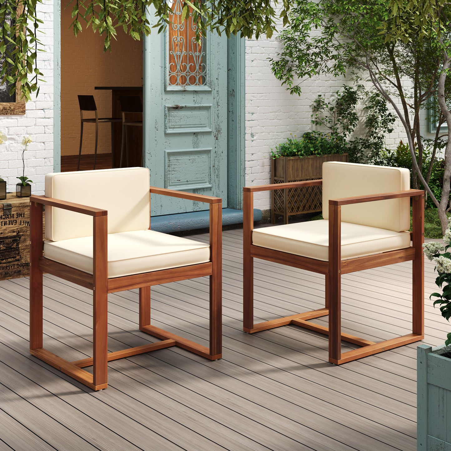 Two modern acacia wood armchairs with cream cushions on a wooden deck