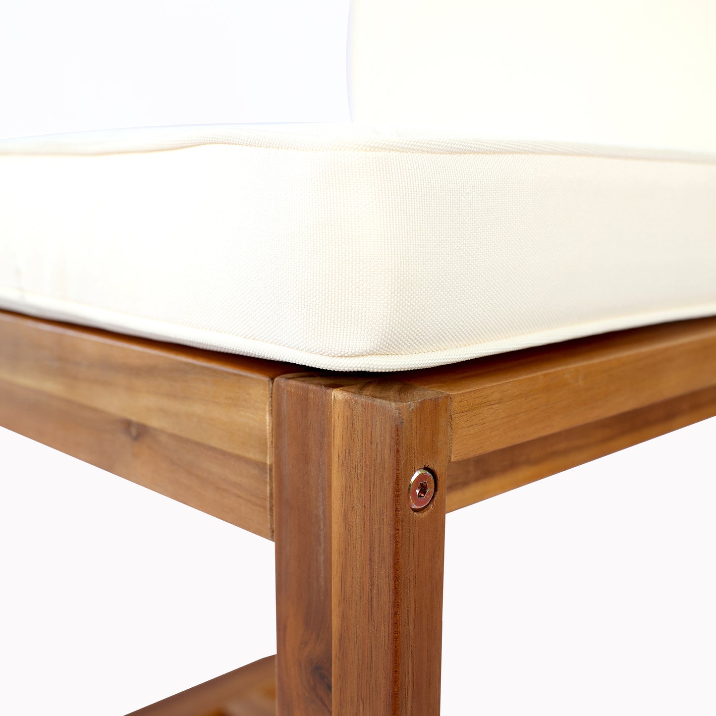Corner detail of a wooden patio bench with offwhite cushion showing natural wood grain