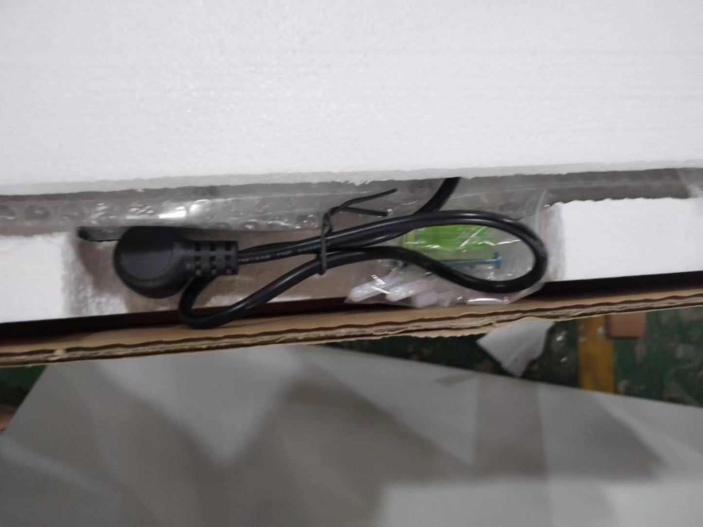 Black power cord with plug neatly coiled and secured with a tie ready for device setup