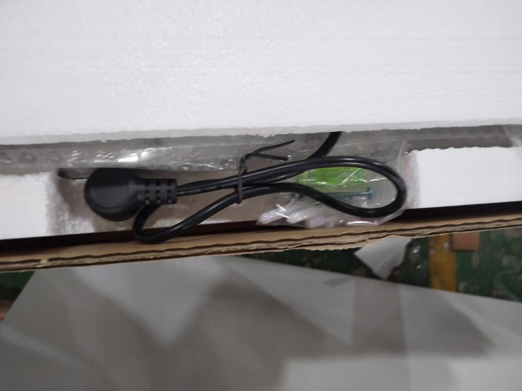 Black power cord with plug neatly coiled and secured with a tie ready for device setup