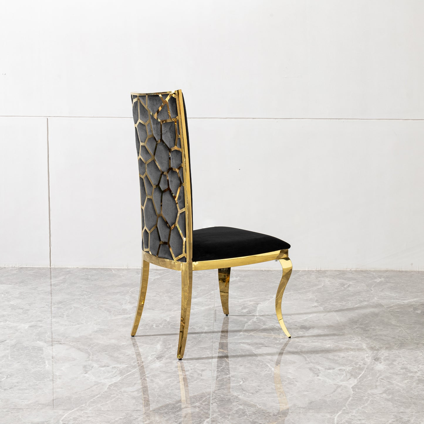 Black velvet dining chair with a gold geometric frame and legs