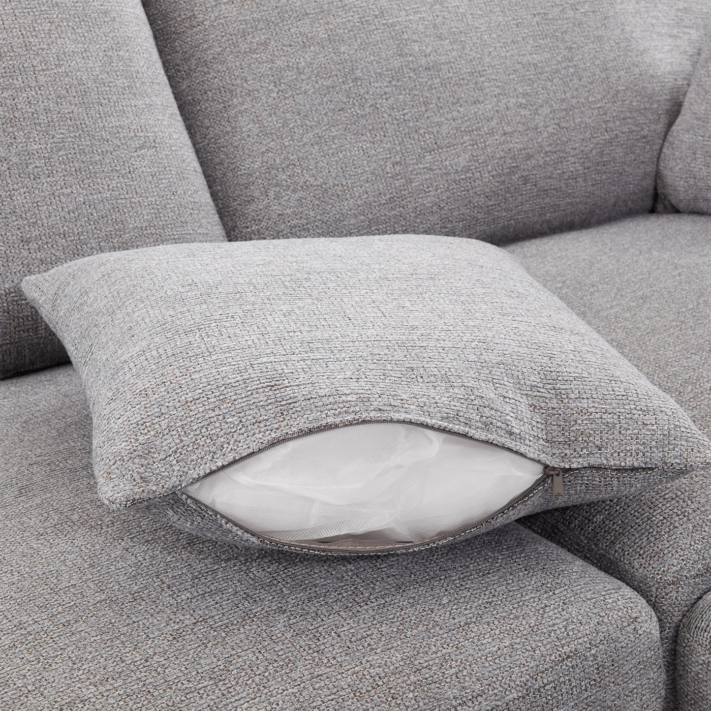 Textured grey throw pillow with exposed white insert and zipper closure