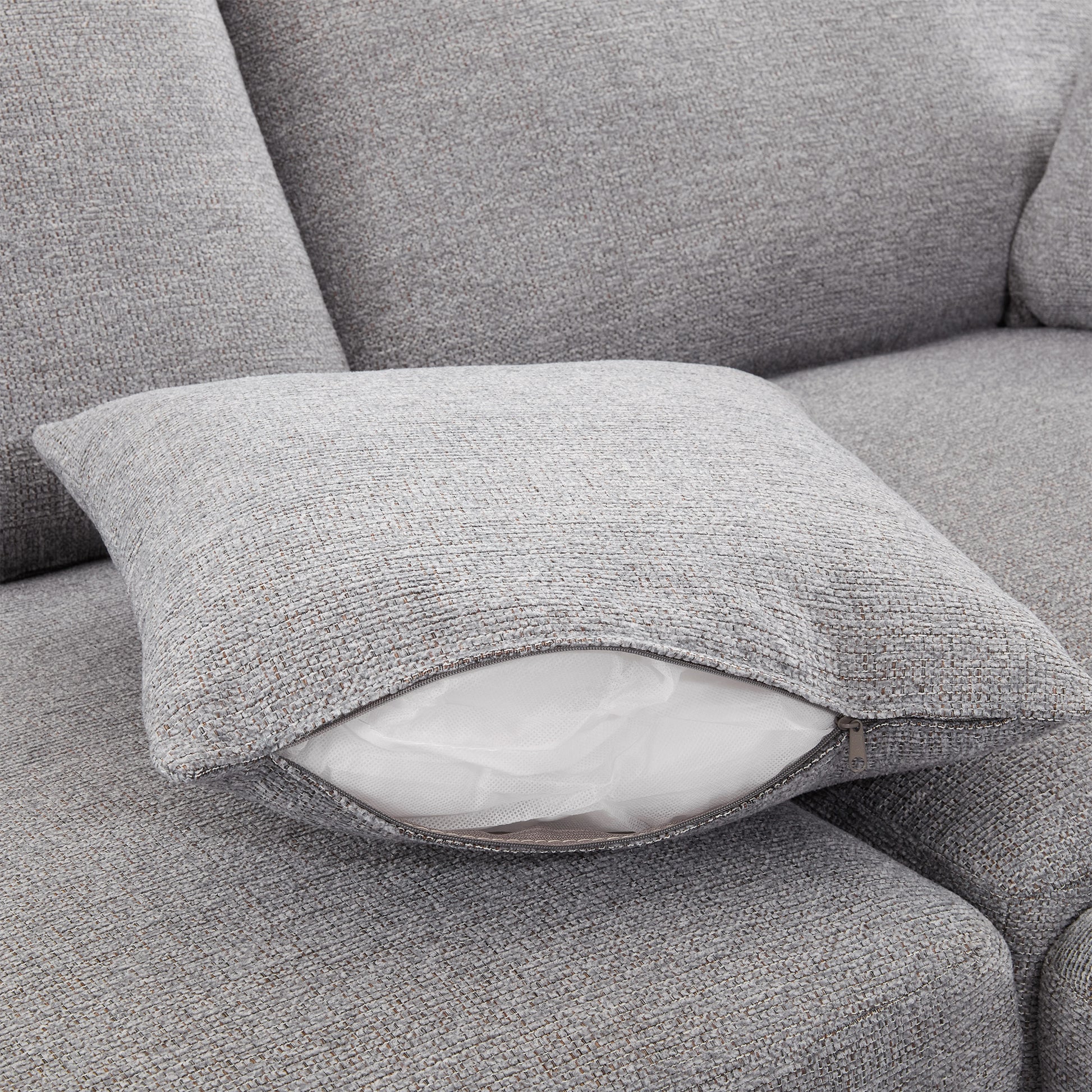 Textured grey throw pillow with exposed white insert and zipper closure