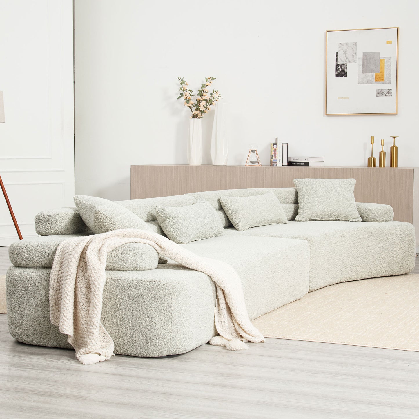 Plush boucle sectional sofa in light grey with throw blanket for cozy living room