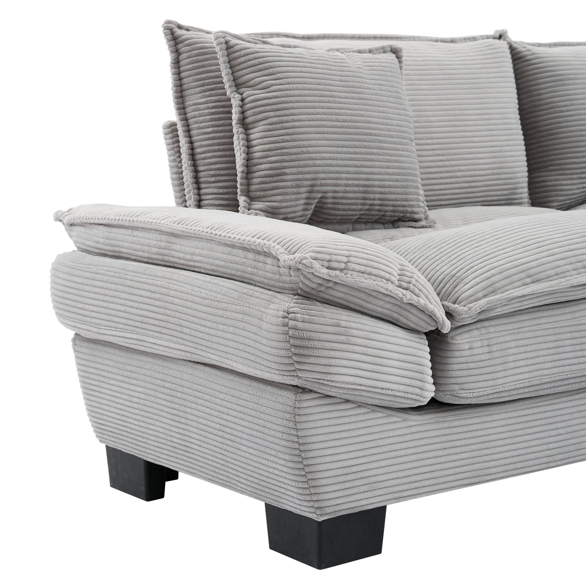 Closeup of a plush gray corduroy sofa with thick cushions and a modern design