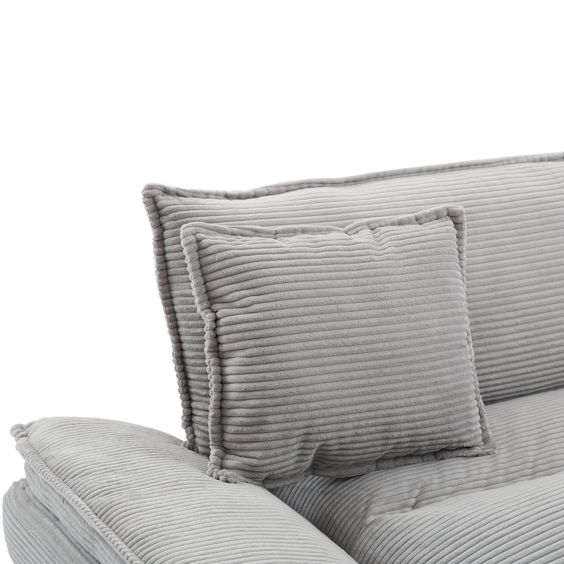Closeup of a plush grey corduroy sofa section with a lumbar cushion