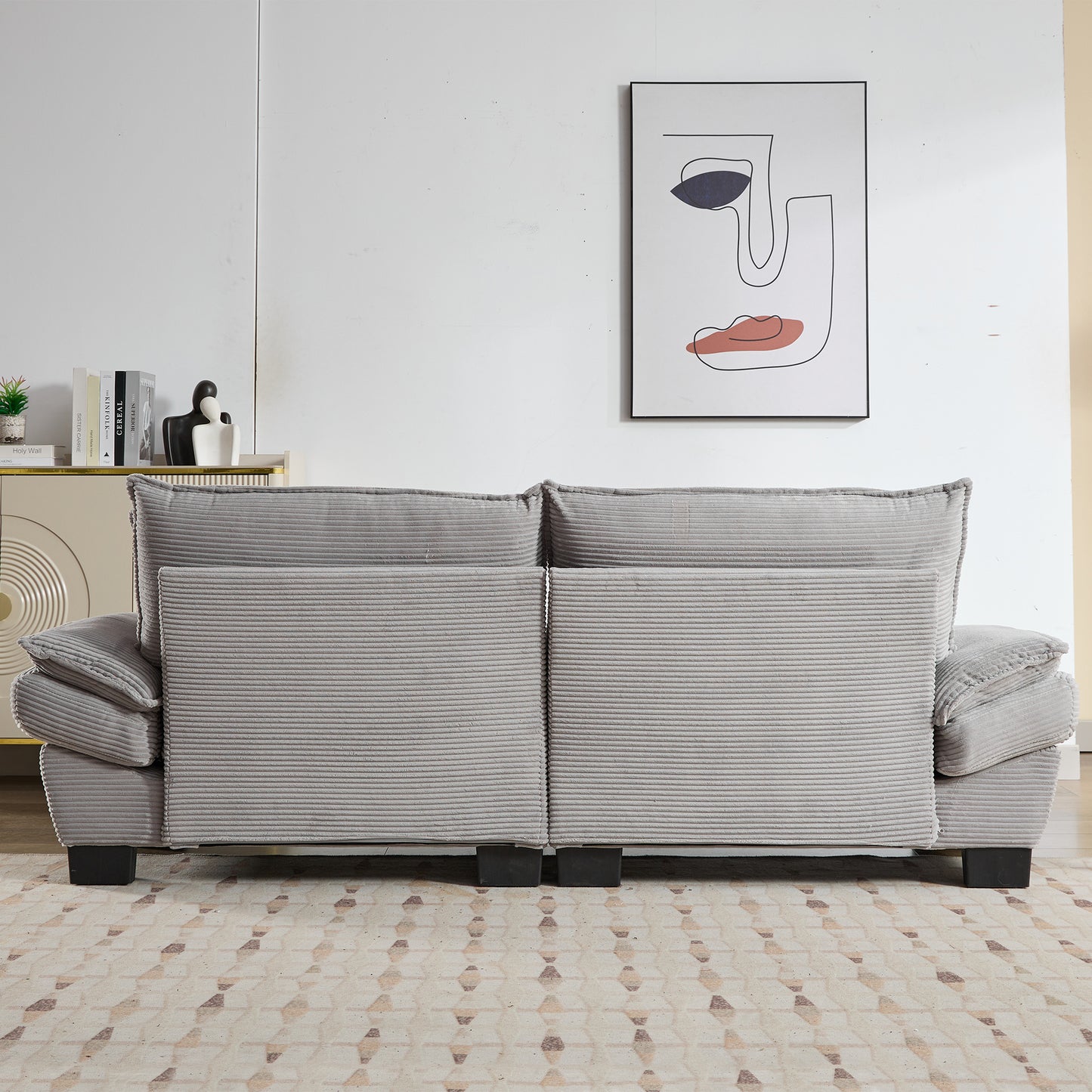 Gray corduroy sofa with plush cushions and dark legs in a living room setting