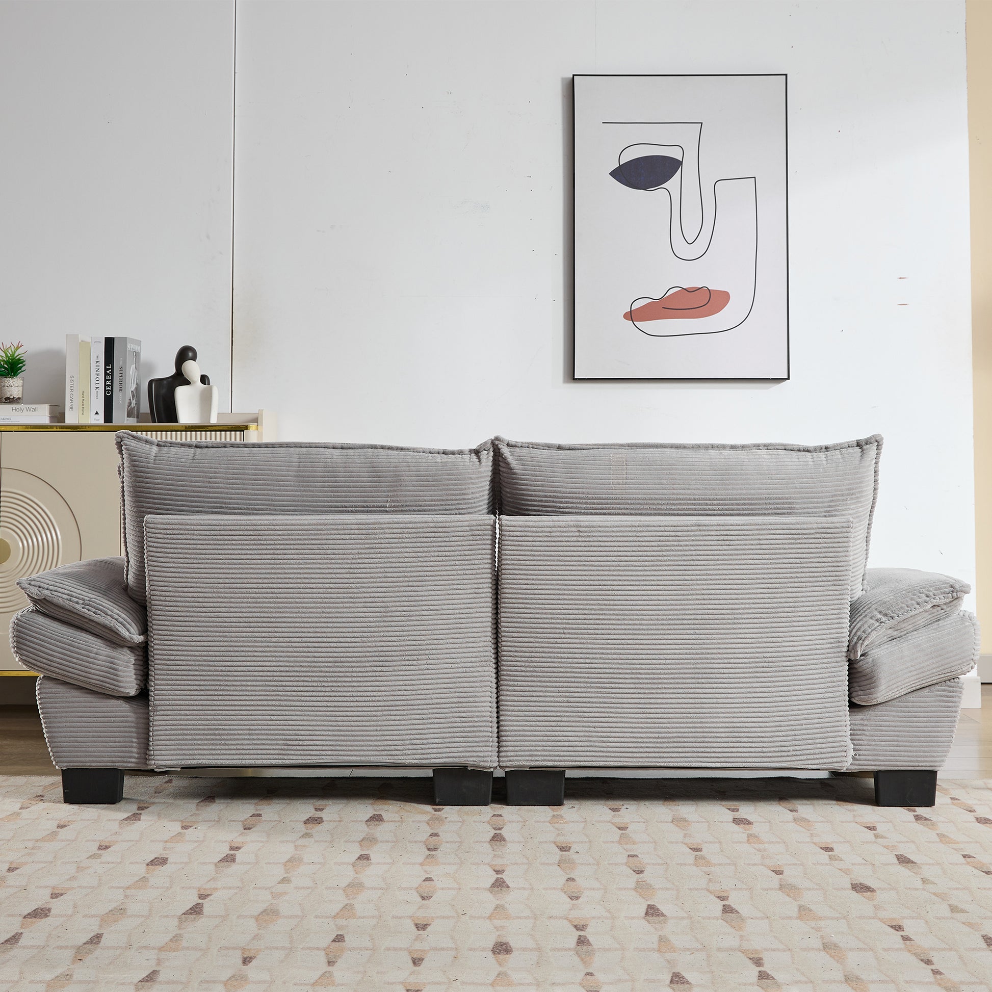 Gray corduroy sofa with plush cushions and dark legs in a living room setting