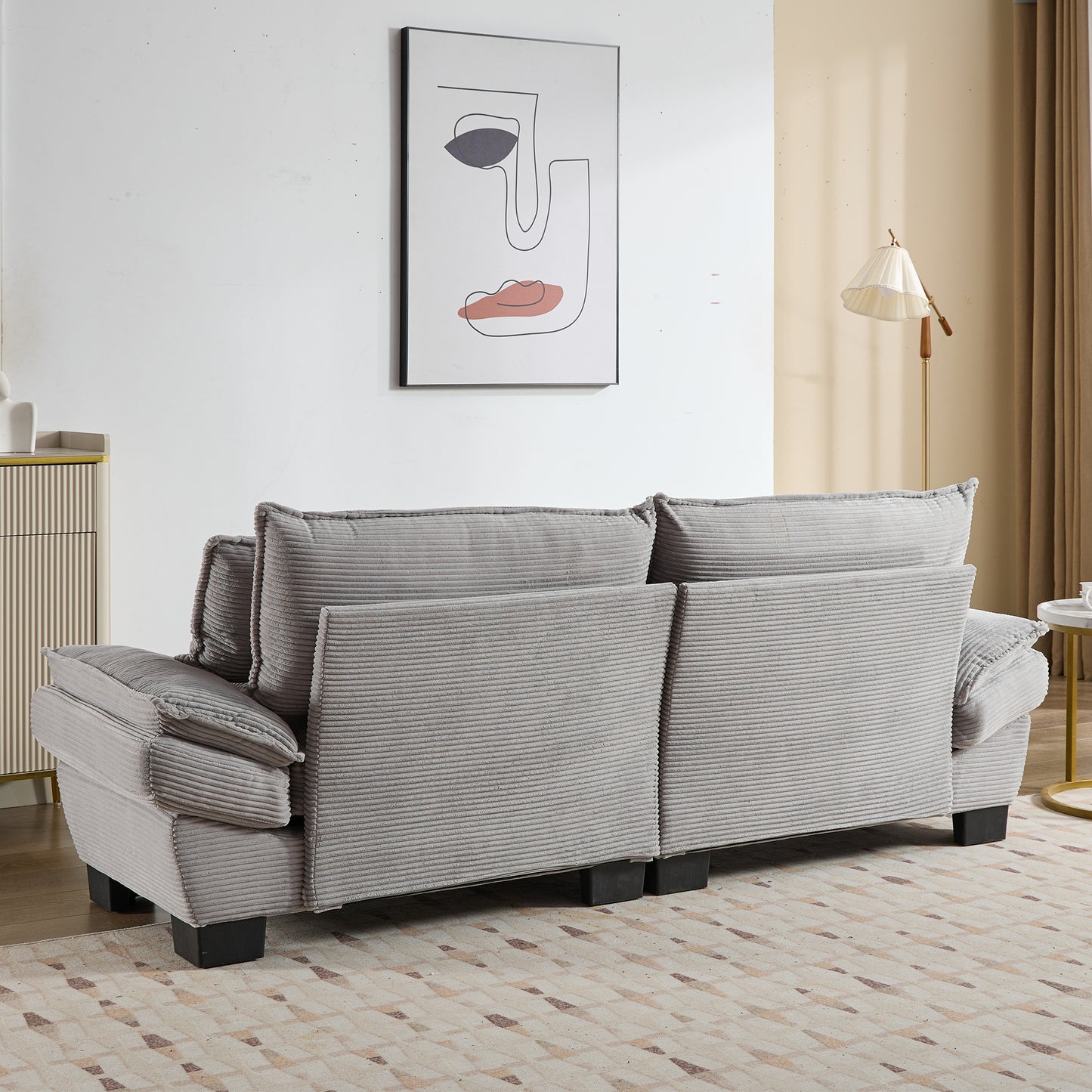 Gray corduroy sofa with plush cushions and wooden legs perfect for a cozy living room