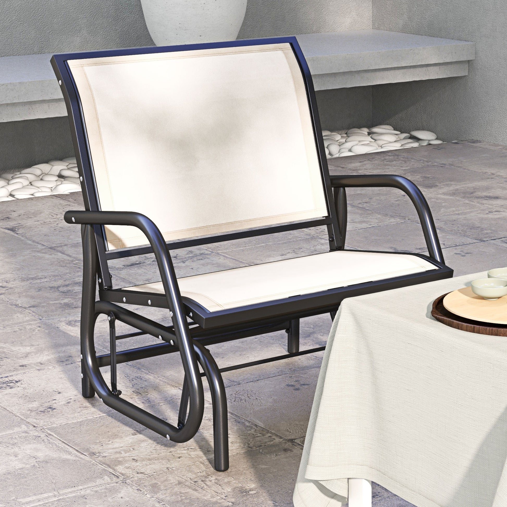 Black metal patio glider with cream fabric seat and back for outdoor relaxation