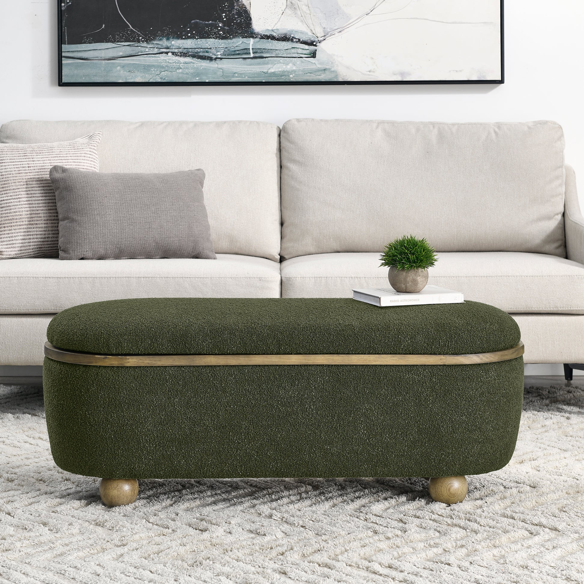 Textured green storage ottoman with brass trim and wood legs