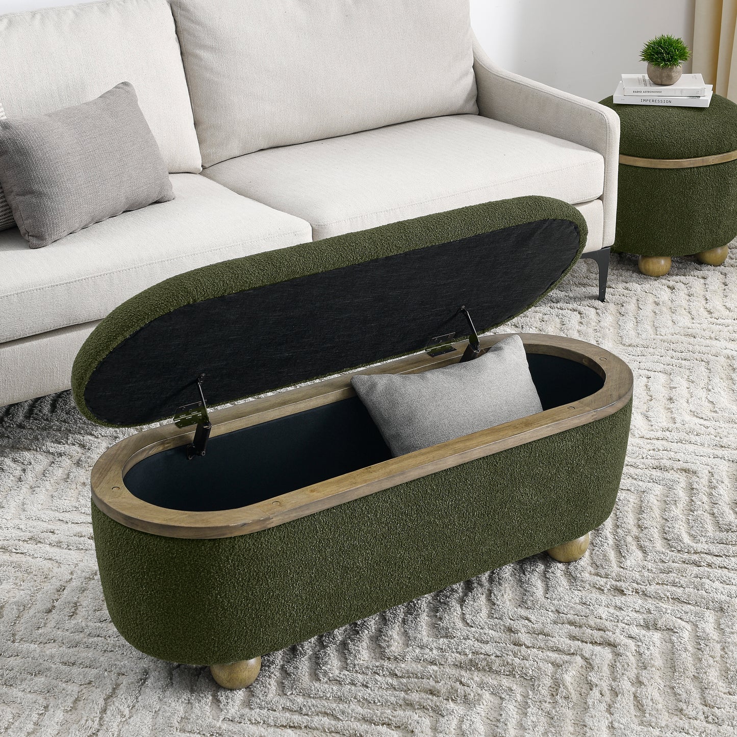 Olive green textured storage ottoman with wooden rim and ball feet open to reveal dark interior